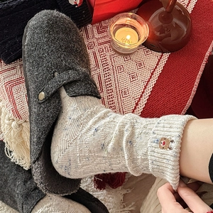 Detail of Christmas reindeer embroidery on thick wool knit socks with warm slippers