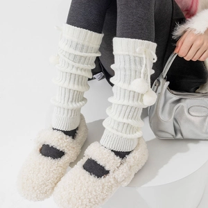 Dettaglio di scaldamuscoli in maglia bianca con pompon e volant in stile Lolita