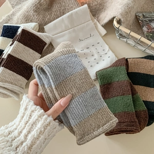 Gros plan de chaussettes en laine épaisses avec divers motifs rayés et texture chaude