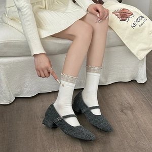Detail of white cotton socks with plaid ruffles and gold bead paired with Mary Janes