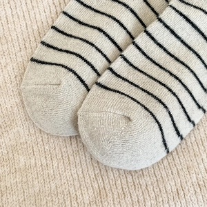 Gros plan sur la texture tricotée et les rayures noires des chaussettes en laine