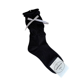 Ballet style black mid-calf socks with grey ribbon bows and ruffled cuffs on white background