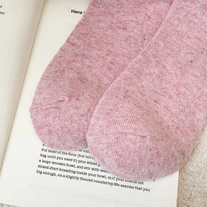 Gros plan de chaussettes en laine tricotées rose chiné avec coutures aux orteils