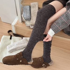 Close-up of thick knit over-knee socks in brown, showing high elasticity and warm texture