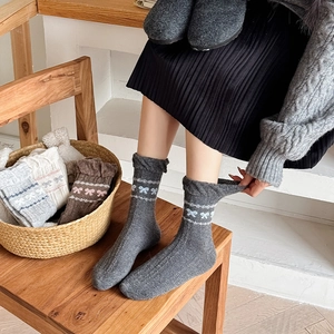 Detailed knit texture of wool mid-calf socks with blue bow jacquard and wavy stripes