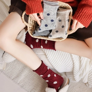 Detail of wool blend polka dot socks with rolled cuffs for a cozy winter vintage look