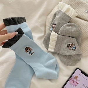 Close-up of cute dog embroidery on sky blue and light grey cotton crew socks