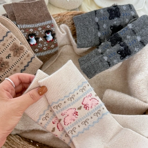 Close-up of thick knit socks featuring cute cartoon animal patterns and ribbed cuffs