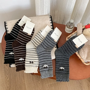 Détail de cinq paires de chaussettes rayées avec broderie de nuage et nœud noir