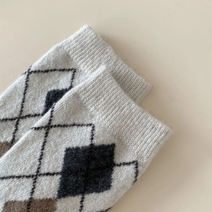 Close-up of diamond argyle pattern knit and ribbed cuffs on thick wool socks