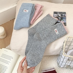 Détail de chaussettes en tricot avec bords en dentelle et étiquettes brodées 'Nice'