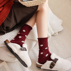Detail of wool blend polka dot crew socks in burgundy with warm sherpa mules