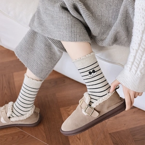 Détail de broderie chiot mignon sur chaussettes rayées et chaussures fourrées douillettes