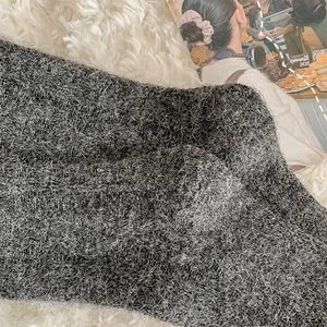 Close-up of thick dark grey plush knit socks with warm textured wool fabric details