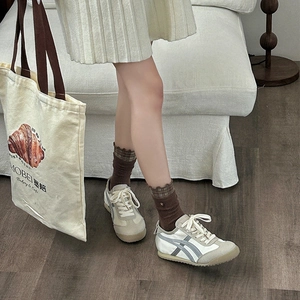 Close-up of retro cream sneakers with grey suede panels and brown crew socks