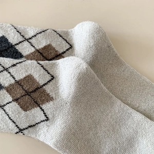 Detailed view of vintage argyle wool socks with soft brushed texture in beige and grey