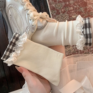Détail de chaussettes beiges avec dentelle et motif à carreaux portées avec chaussures