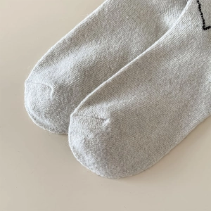 Close-up of the reinforced toe seam on light grey marl wool blend knitted socks