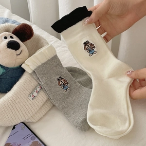 Detail of cute puppy embroidery on cotton crew socks with contrasting ruffle edges