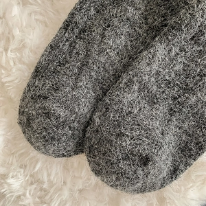 Close-up of thick knit dark gray wool blend socks with warm fuzzy texture and fibers