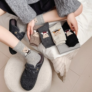 Detailed close-up of thick winter mid-tube socks featuring cute flocked bear embroidery
