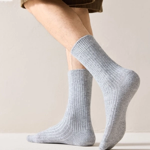 Detail of grey rib-knit wool socks showing thick texture and elastic fit for men