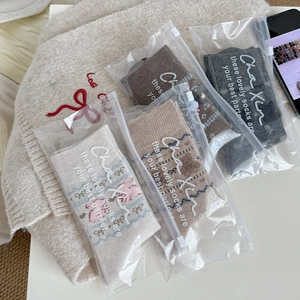 Set of four knitted thermal socks in neutral tones with individual frosted zipper bags