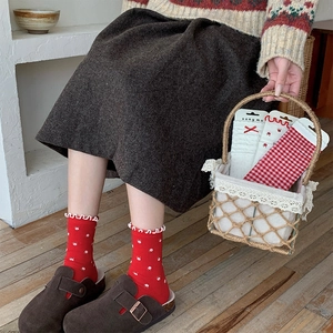 Detail of red floral knit socks with frilled cuffs and checkered patterns in a basket