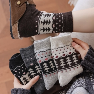 Detail of five pairs of warm knitted socks featuring Nordic Christmas tree and heart patterns
