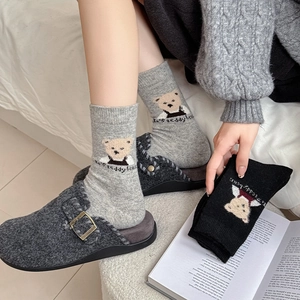 Close-up of thick knitted crew socks with cute teddy bear pattern and embroidery