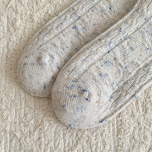 Close-up of winter wool blend crew socks showing ribbed knit texture and tweed yarn details