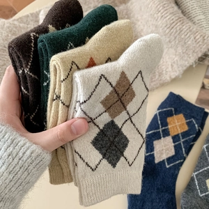 Detail of wool blend argyle knit socks in various autumn colors stacked for texture