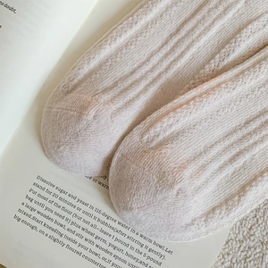 Detailed close-up of cream wool blend socks with hollow knit and vertical rib texture