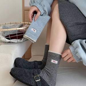 Détail de chaussettes en laine avec bordure en dentelle et broderie 'Nice' côtelée