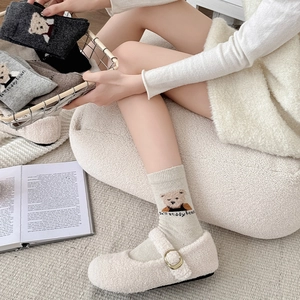 Close-up of fluffy teddy bear pattern on cream ribbed socks with stylish lambskin shoes