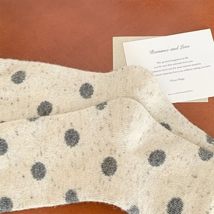 Detail of beige wool blend socks with grey polka dots and textured nep yarn material