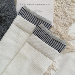 Detailed close-up of striped ribbed cuff on off-white Japanese style college socks