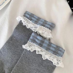 Détails de chaussettes grises avec carreaux bleus et bordure en dentelle blanche