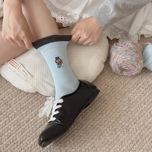 Detail of light blue crew socks with puppy embroidery and dark grey contrast trim