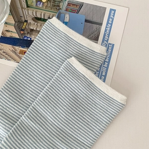 Close-up of light blue and white striped knitted socks with fine ribbed edges
