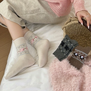 Close-up of thick knitted crew socks with cute cartoon bear and rabbit jacquard patterns