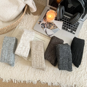 Close-up of six neutral-colored thick ribbed knit winter over-knee socks set