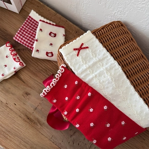Detailed knit texture of red bow floral socks with cartoon bear patterns and ruffled edges