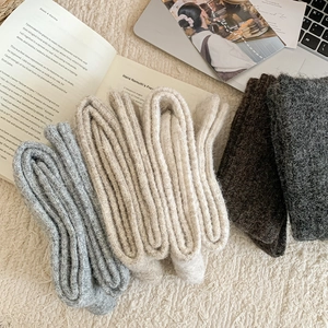 Close-up of wool blend knee-high socks in neutral tones showing fluffy knit texture