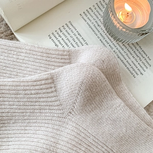 Detail of warm milk tea knit socks with shell buttons and thick wool texture