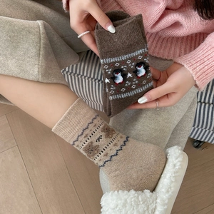 Close-up of thick winter knit crew socks with cute bear and penguin patterns