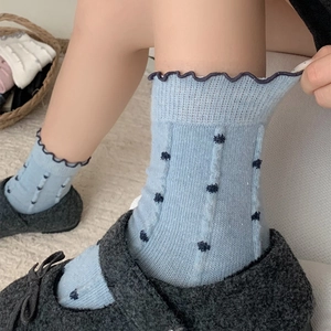 Detail of light blue polka dot wool socks with ruffled edges and vertical ribbed texture