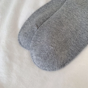 Détail de la couture plate sur les orteils des chaussettes grises en tricot dentelle