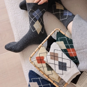 Detailed knit texture of Argyle patterned wool socks in grey, beige and navy colors
