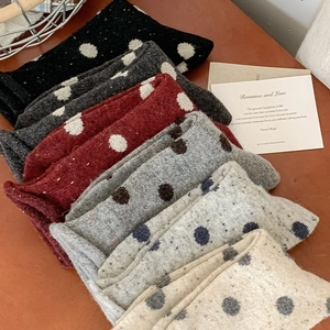 Close-up of thick knitted wool socks with polka dot pattern in multiple vintage colors